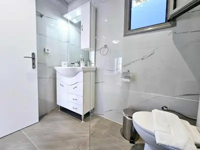 a white bathroom with a sink and a toilet at Dream Luxury Apartment Suites in Pastida