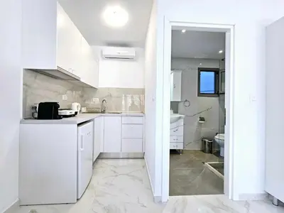 a white kitchen with white cabinets and a sink at Dream Luxury Apartment Suites in Pastida