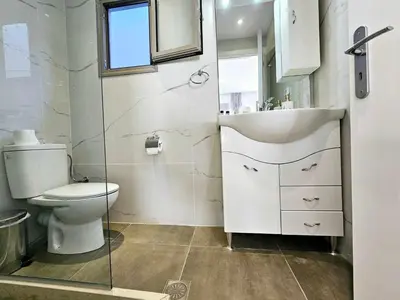 a white bathroom with a toilet and a sink at Dream Luxury Apartment Suites in Pastida