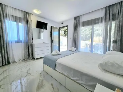 a bedroom with a large bed and a large window at Dream Luxury Apartment Suites in Pastida
