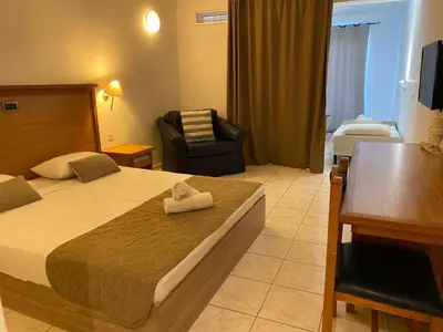 a hotel room with a bed and a chair and a desk at Cyprotel Faliraki in Faliraki