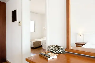 a bedroom with a bed and a mirror and a table at Cyprotel Faliraki in Faliraki