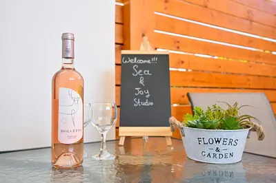 a bottle of wine sitting on a table with a glass at Sea & Joy Studio in Ialyssos