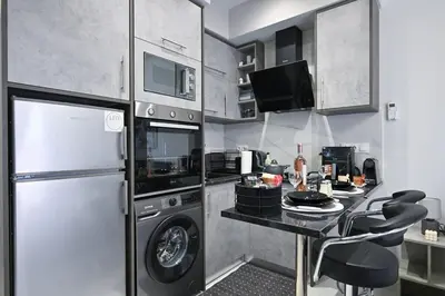 a kitchen with a refrigerator and a counter with a table at Sea & Joy Studio in Ialyssos