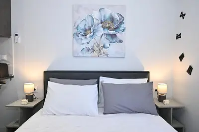 a bedroom with a bed with a blue flower painting on the wall at Sea & Joy Studio in Ialyssos