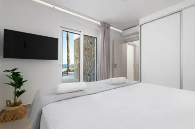 a white bedroom with a large bed and a large window at Luxurious Villa with sea views in Gennadi Rhodes in Gennadi