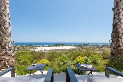a patio with two tables and a view of the beach at Luxurious Villa with sea views in Gennadi Rhodes in Gennadi