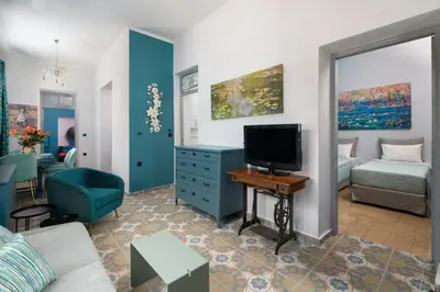 a living room with a couch and a tv in it at Plumeria House in Rhodes Town