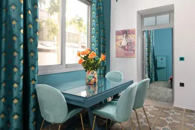 a dining room with a blue table and chairs at Plumeria House in Rhodes Town