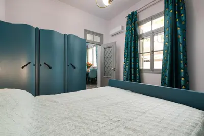 a bedroom with a blue and white bed and a window at Plumeria House in Rhodes Town