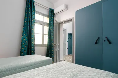 a bedroom with two beds and a window at Plumeria House in Rhodes Town