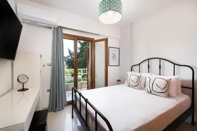 a bedroom with a bed and a window at Dora 3 bedroom apartment in Rhodes Town
