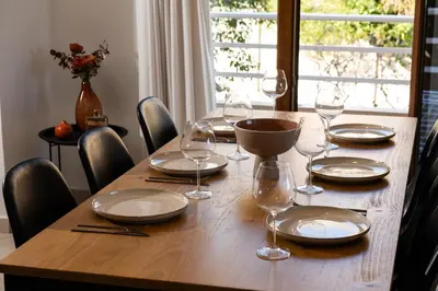 a wooden table with plates and wine glasses on it at Dora 3 bedroom apartment in Rhodes Town