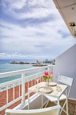a balcony with a table and chairs and the ocean at Serene Ocean Haraki in Haraki