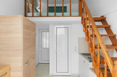 a kitchen with a staircase leading up to a loft at Serene Ocean Haraki in Haraki