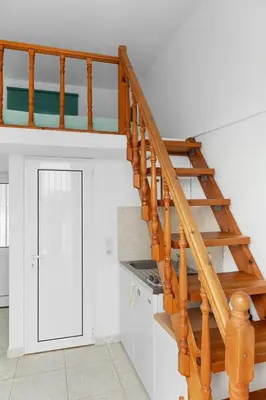 a wooden staircase in a room with a door at Serene Ocean Haraki in Haraki