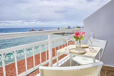a balcony with a table and chairs and the ocean at Serene Ocean Haraki in Haraki