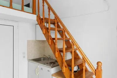 a wooden staircase in a kitchen with a sink at Serene Ocean Haraki in Haraki