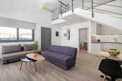 a living room with a purple couch and a table at Stone Apartments in Kremasti
