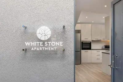 a white stone apartment sign on the wall of a kitchen at Stone Apartments in Kremasti