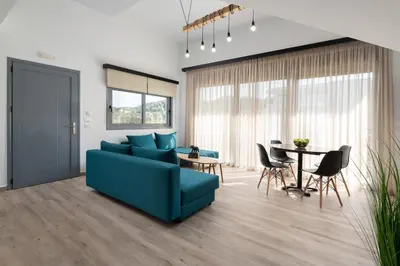 a living room with a blue couch and a table at Stone Apartments in Kremasti