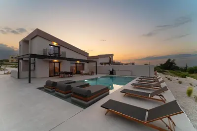a villa with a swimming pool and lounge chairs at Luma Villas in Rhodes Town