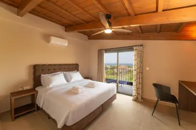 a bedroom with a bed and a large window at Luma Villas in Rhodes Town