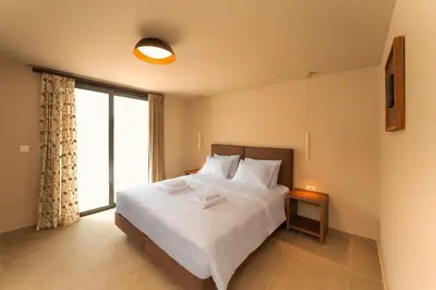 a bedroom with a large white bed with a window at Luma Villas in Rhodes Town