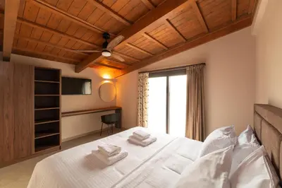 a bedroom with a large white bed with a window at Luma Villas in Rhodes Town