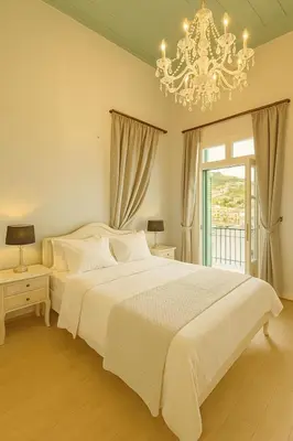 a bedroom with a large white bed and a chandelier at 