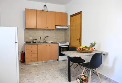 a kitchen with a table with a bowl of fruit on it at Casa 30 House Complex Center of Ialysos in Ialyssos