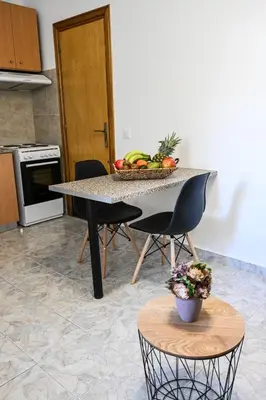 a kitchen with a table with a bowl of fruit at Casa 30 House Complex Center of Ialysos in Ialyssos