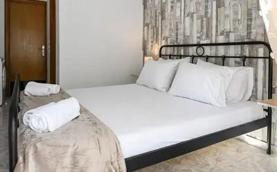 a bed with white sheets and pillows in a room at Casa 30 House Complex Center of Ialysos in Ialyssos