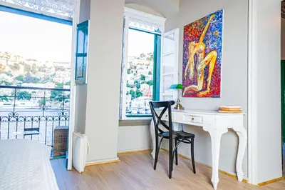 a bedroom with a desk with a painting on the wall at 