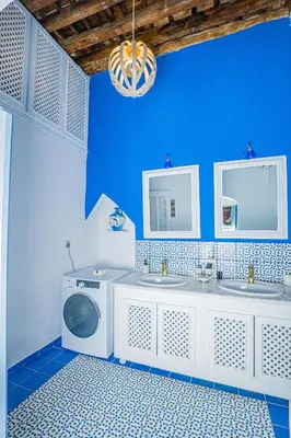 a blue bathroom with two sinks and a washing machine at 