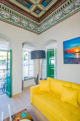 a yellow couch in a living room with a ceiling at 