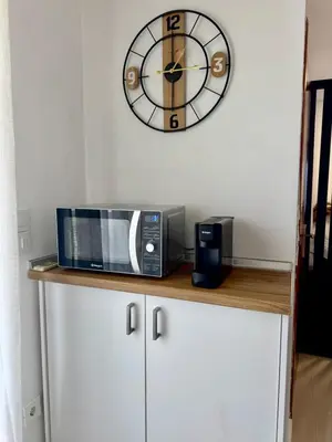 a microwave sitting on top of a counter with a clock at Papas house 2 near Faliraki kalithies in Kalithies