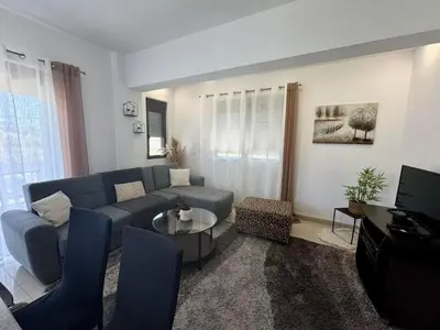 a living room with a blue couch and a tv at Papas House 3 near Faliraki Kalithies in Kalithies