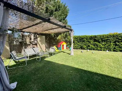 a backyard with a pergola and chairs on the grass at Papas House 3 near Faliraki Kalithies in Kalithies