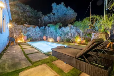 a swimming pool in a garden at night at Eros Elysium Retreat Villas in Kalavárda