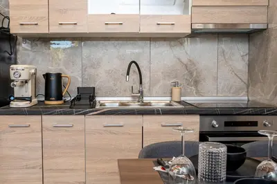 a kitchen with wooden cabinets and a sink at Eros Elysium Retreat Villas in Kalavárda