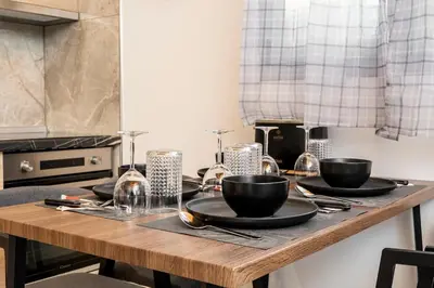 a wooden table with black bowls and plates on it at Eros Elysium Retreat Villas in Kalavárda