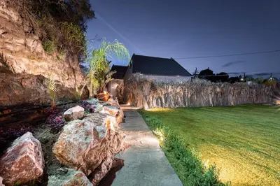 a garden with rocks next to a house at Eros Elysium Retreat Villas in Kalavárda