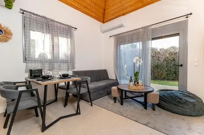 a living room with a couch and a table at Eros Elysium Retreat Villas in Kalavárda