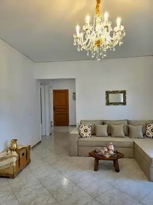 a living room with a couch and a chandelier at City Center Luxury Spacious apt A&M II in Rhodes Town