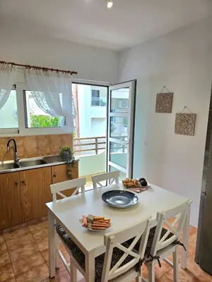 a kitchen with a white table and chairs in a kitchen at City Center Luxury Spacious apt A&M II in Rhodes Town
