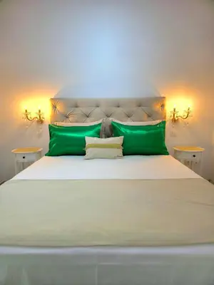 a bedroom with a large bed with green pillows at City Center Luxury Spacious apt A&M II in Rhodes Town