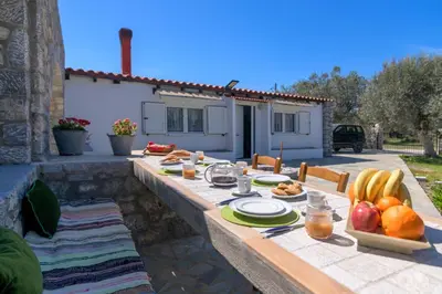 a table with food and fruit on it in front of a house at Billys House in Lardos