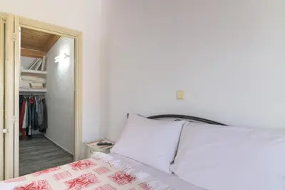 a bedroom with a white bed and a mirror at Billys House in Lardos