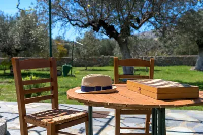 a hat sitting on a wooden table with two chairs at Billys House in Lardos